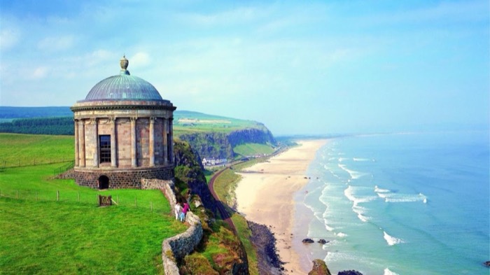 The open sand of Downhill Beach with Mussenden Temple on the cliffs in the distance