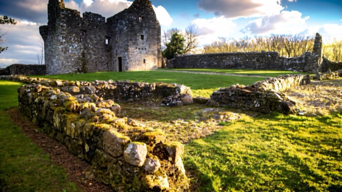 The ruins and old walls of Tully Castle in low golden light
