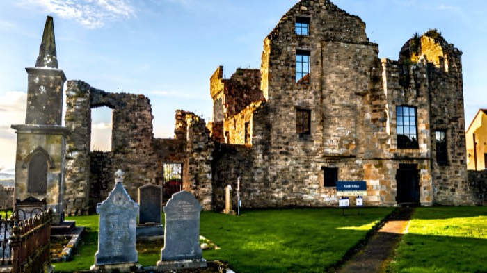 Castle Balfour rising behind the headstones of Lisnaskea churchyard
