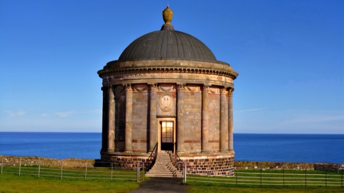 Mussenden Temple standing on the clifftop against a deep blue sea