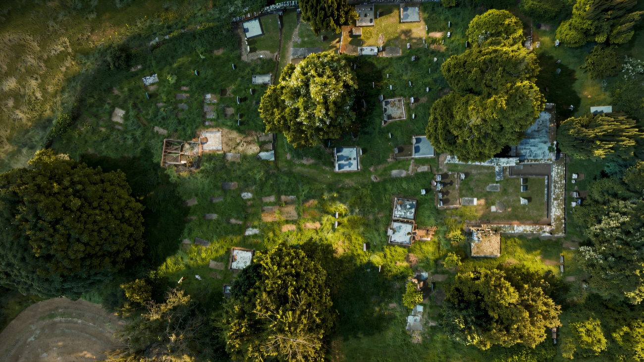 Looking straight down on the old church ruins and the surrounding graveyard, ringed by trees and green fields