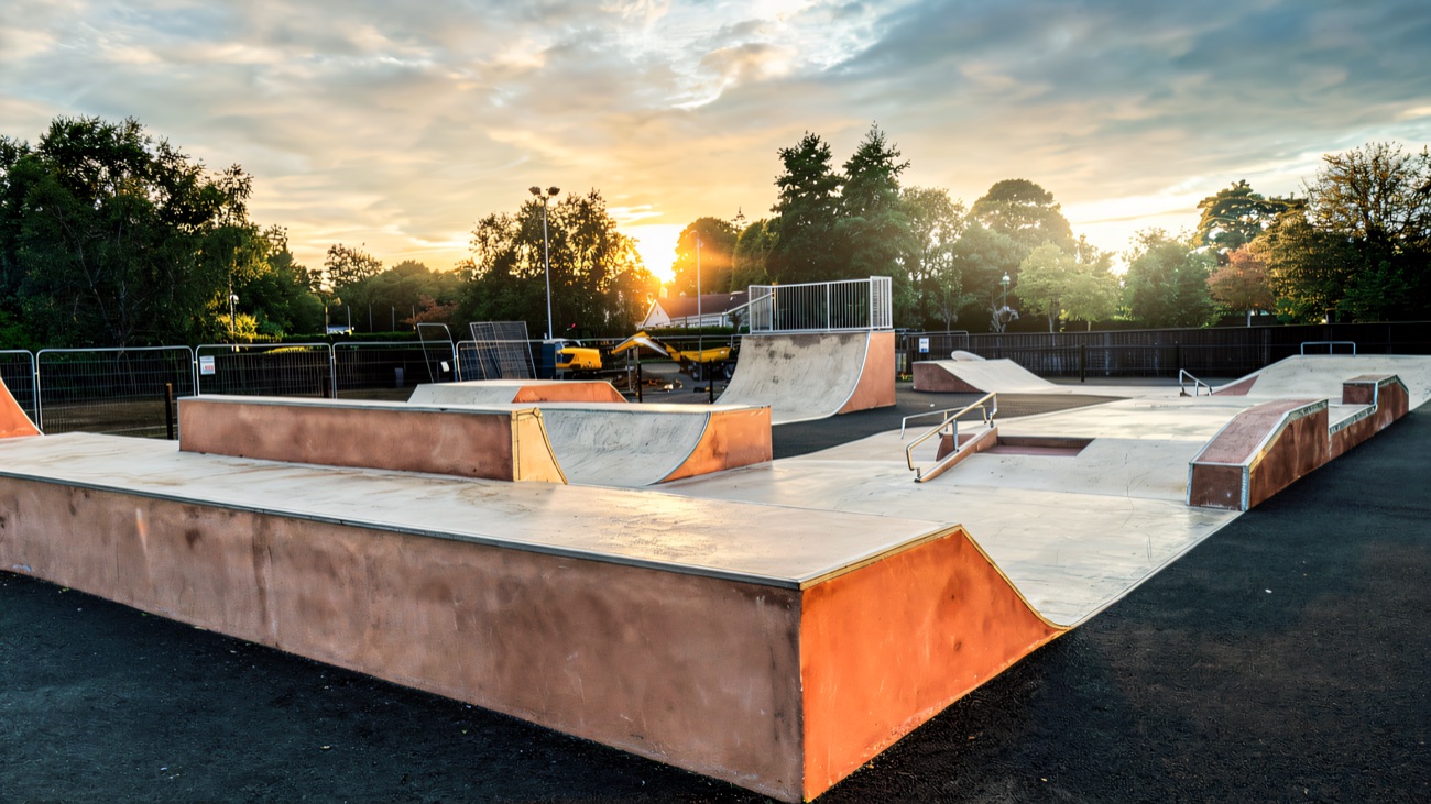 Concrete ledges, rails and quarter pipes with the park's mature trees behind