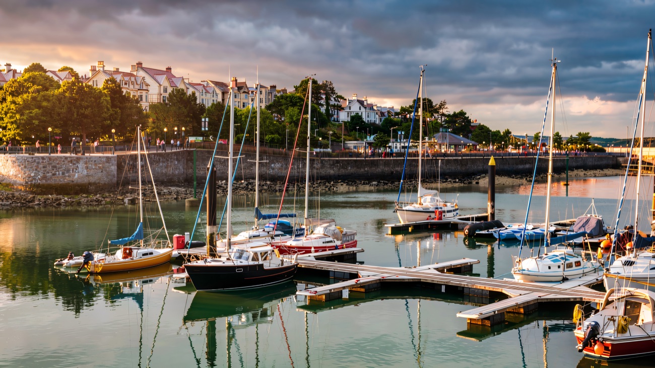 Sailing boats resting on their moorings with Bangor seafront beyond