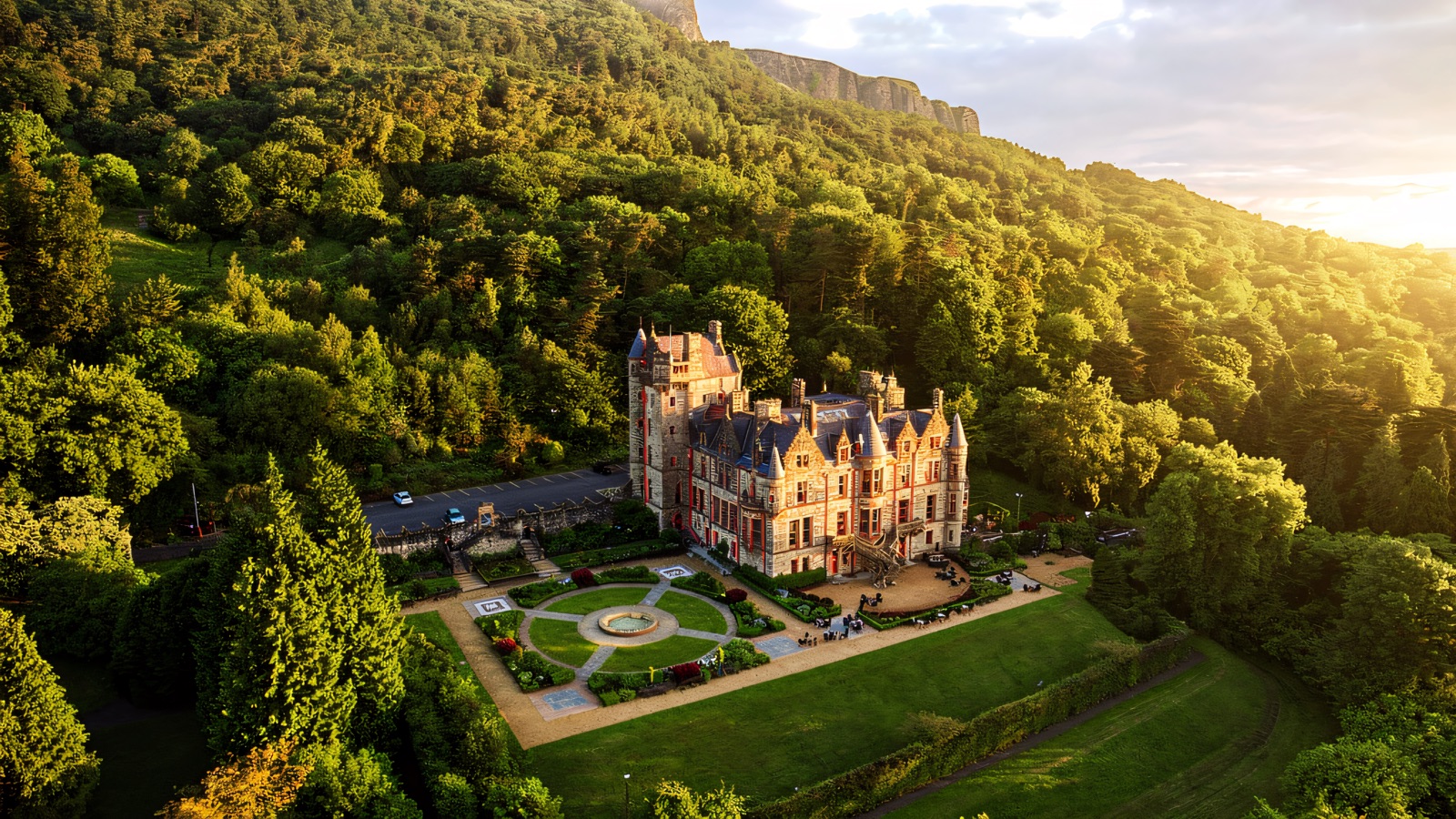 Belfast Castle in golden light with its terraced gardens and the cliff of Cave Hill rising behind