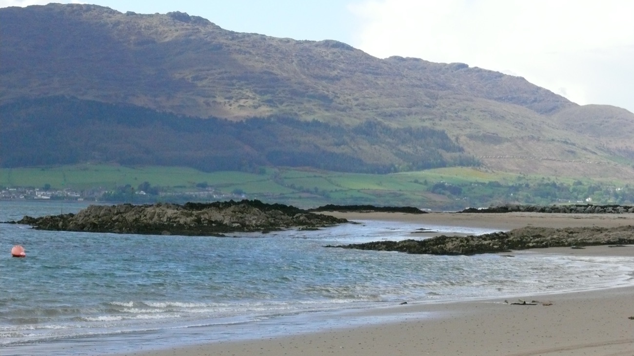 Sandy shore and clear shallow water at Cranfield Beach with the Cooley Mountains across Carlingford Lough
