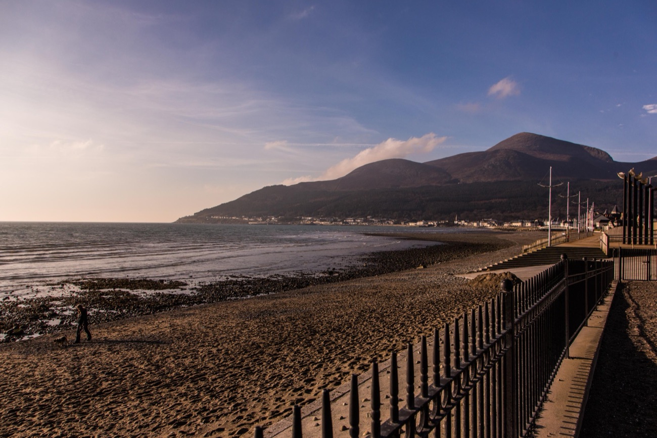 Newcastle promenade and beach below the Mourne Mountains — the Rock Pool lido sits at the south end of this front