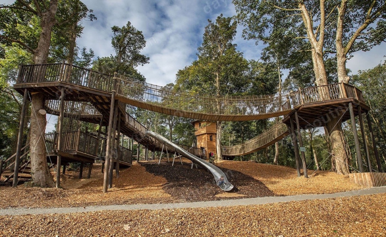 Raised timber walkways and a long silver slide curving between tall trees on the Montalto Estate play trail