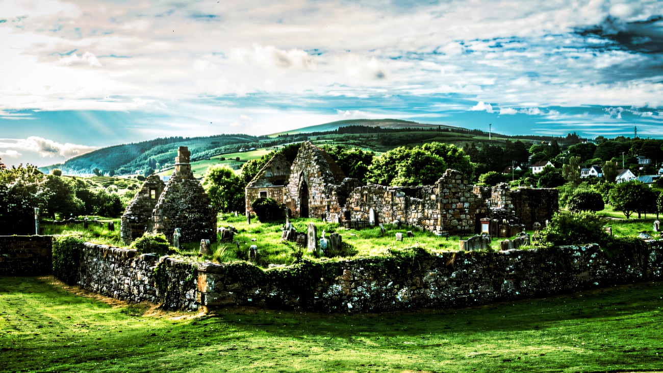 The whole complex in its graveyard with green hills rolling behind