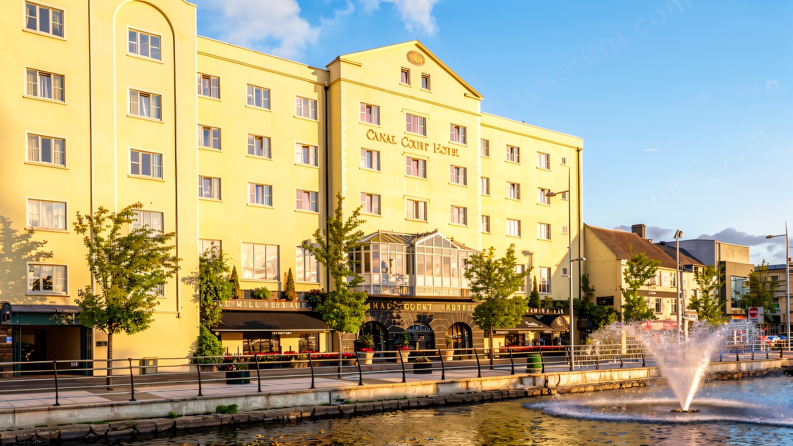 Canal Court Hotel & Spa on the canal in the centre of Newry, its pale front lit up above the water.