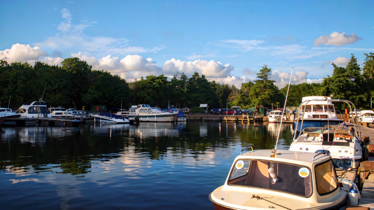 Castle Archdale marina on Lower Lough Erne, small cruisers and motorboats moored along the pontoons with wooded shore behind