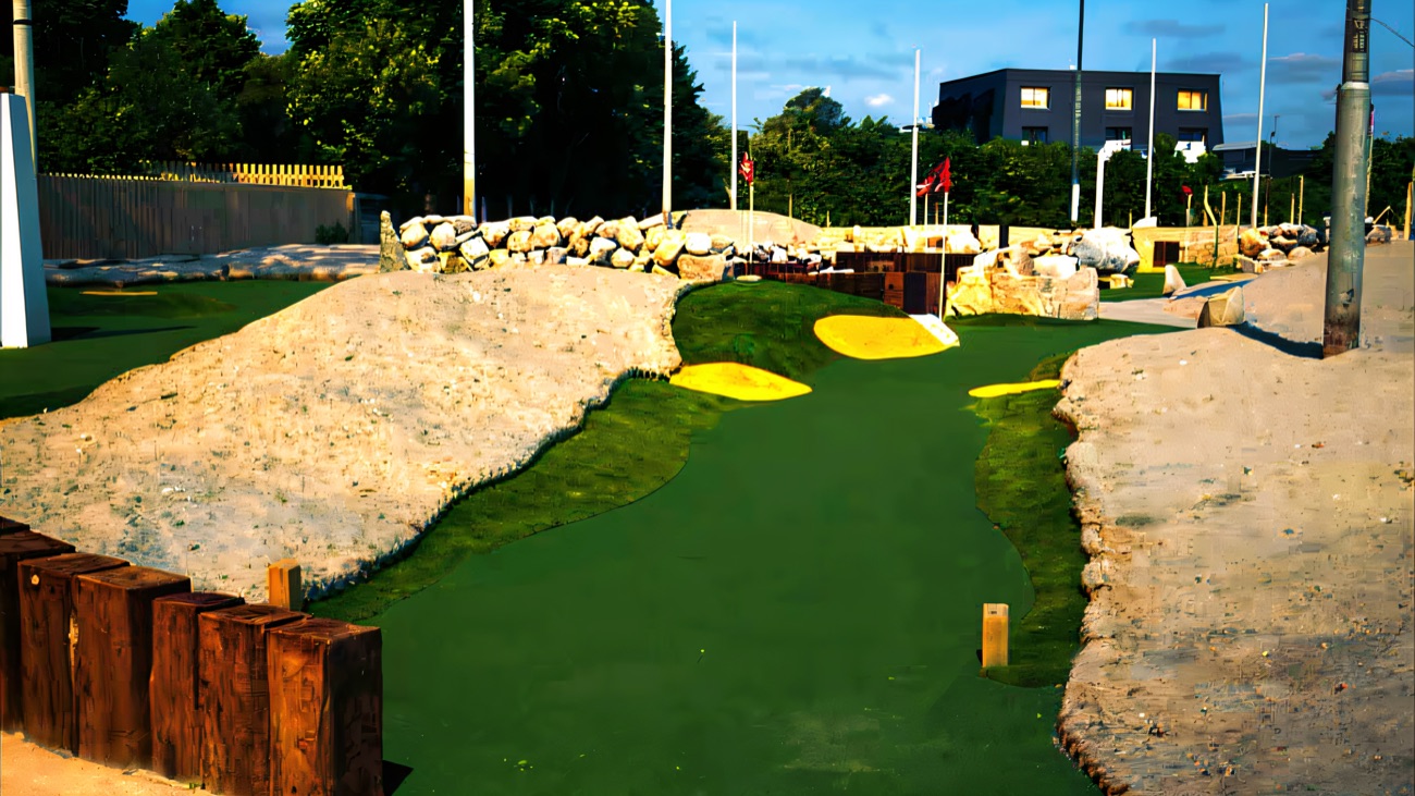 Sand-bunker holes and red flags on the adventure golf course beside the promenade