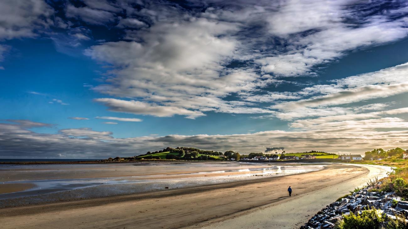 The long sweep of Cloughey beach curving toward Burr Point under a big Ards sky.