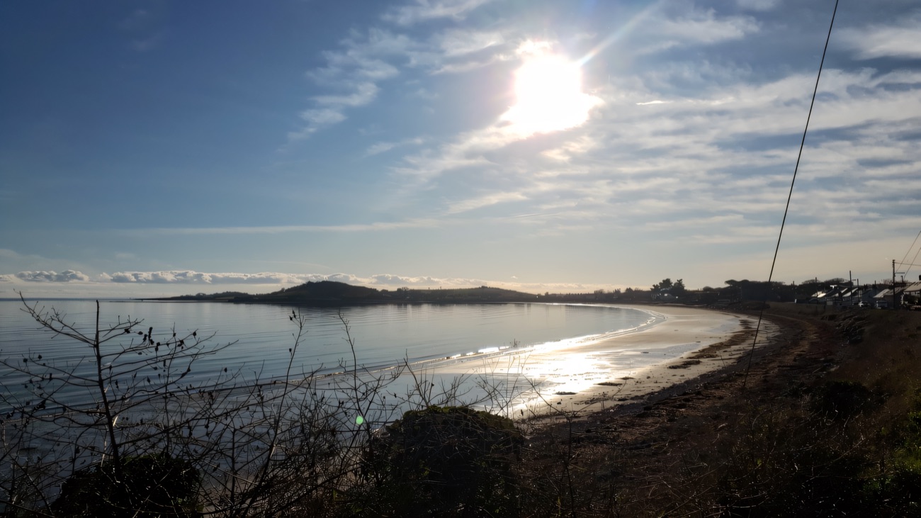Winter sun glinting off the bay as the shoreline curls around toward the village.