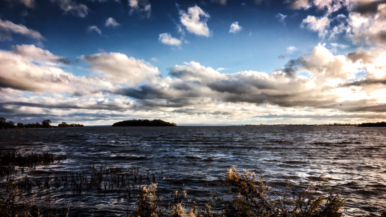 A wide view across Lough Neagh with the island low on the horizon