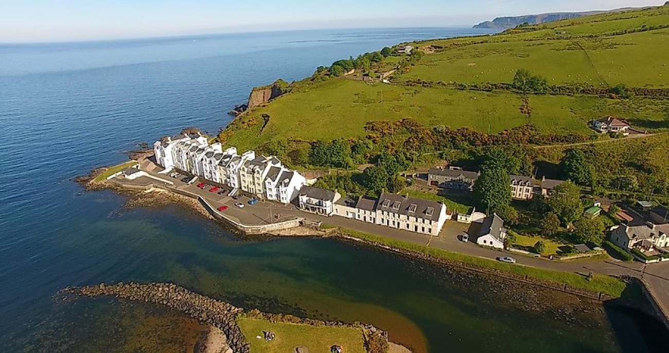 Aerial view of the white terraced cottages at Cushendun village beside the sea
