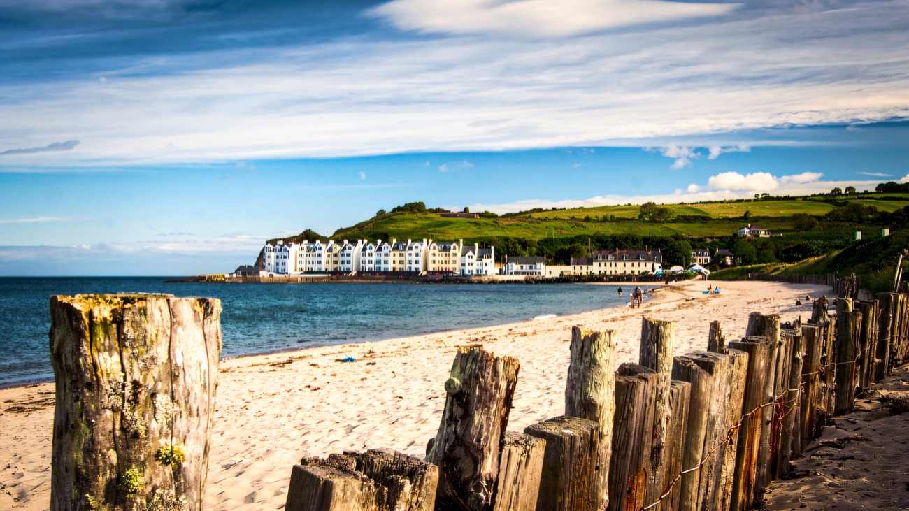 Cushendun's sandy beach with the white terrace of village houses across the bay