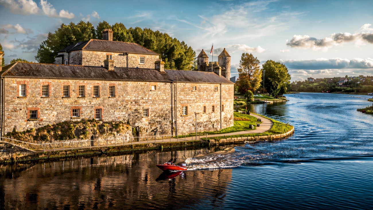 Enniskillen Castle and its old stone barracks beside the River Erne with a boat passing