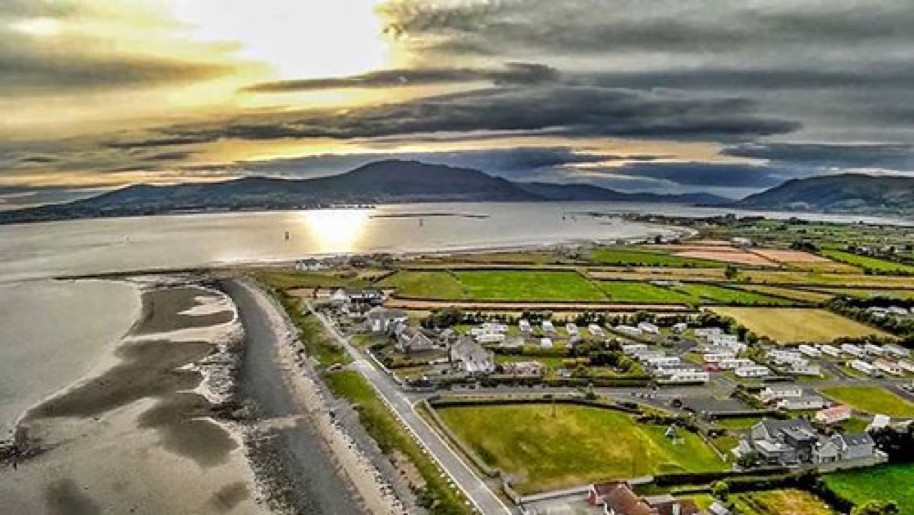 Aerial view of Cranfield Beach at the mouth of Carlingford Lough at sunset, with the Cooley Mountains across the water