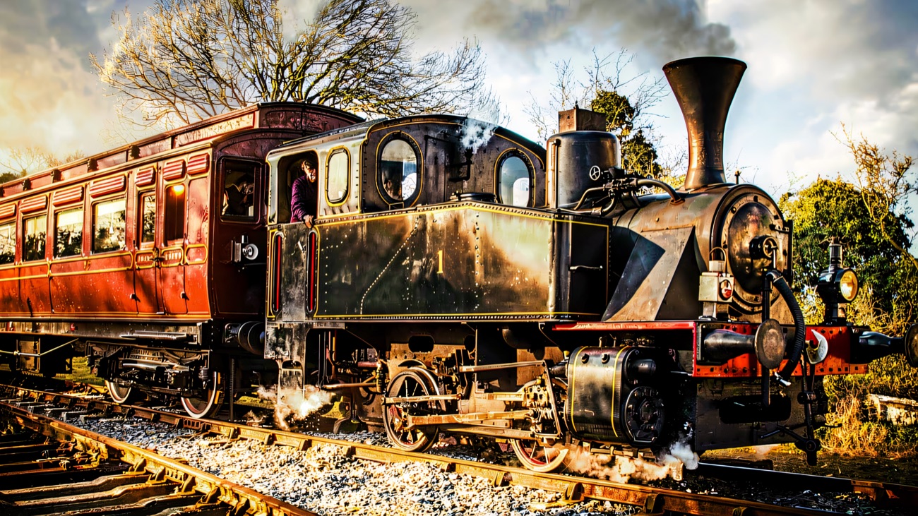 Engine No. 1 simmering trackside, its crimson coaches waiting behind.