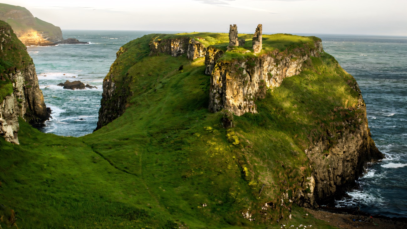 A wider view of the broad green promontory the castle crowns, with the Atlantic wrapping around both sides.