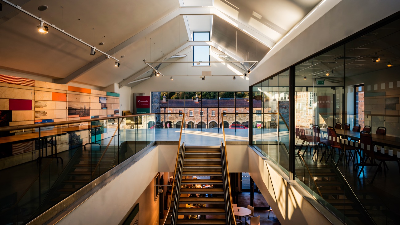Inside the museum at Enniskillen Castle — a bright modern gallery with a glass balustrade and a view out over the castle courtyard