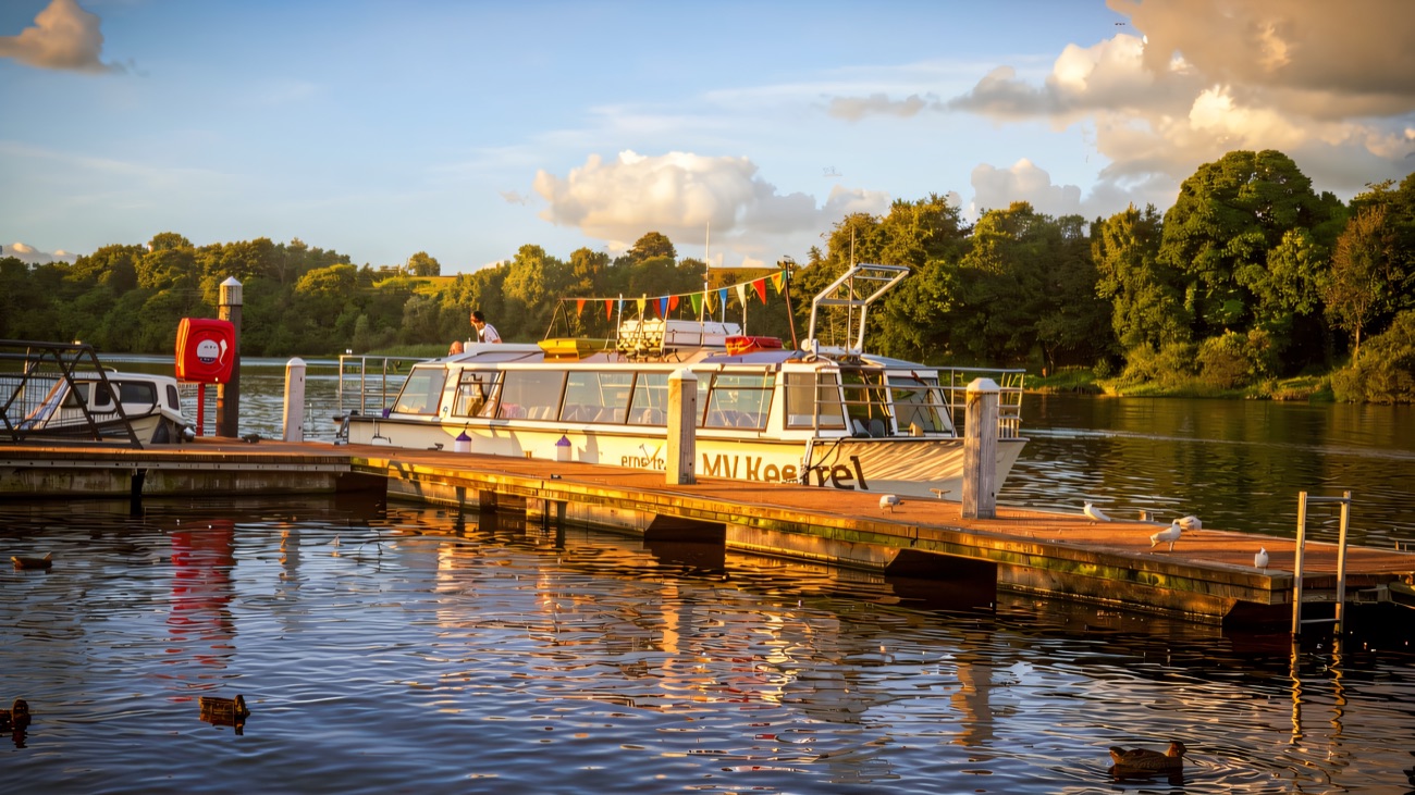 The Kestrel tied up at the jetty on a sunny day, ducks on the water