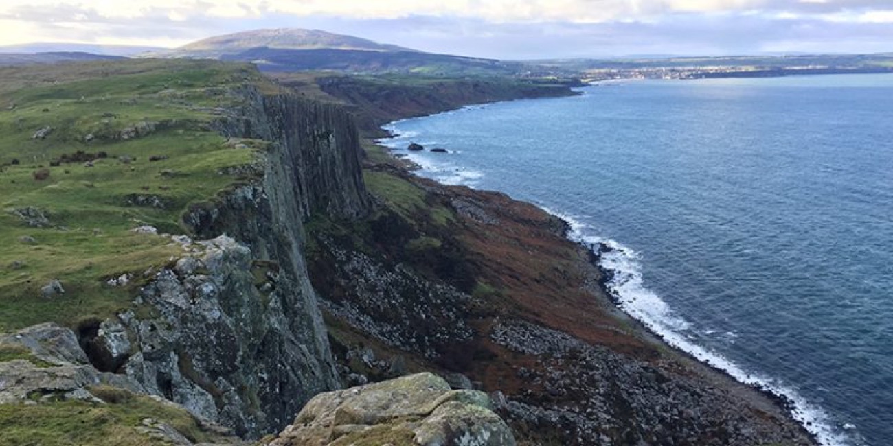 The clifftop path along Fair Head looking down the coast towards Ballycastle across blue water