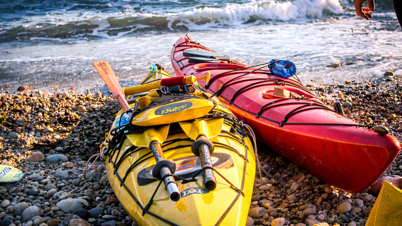 Kayaks pulled up on the shingle, ready for the next launch