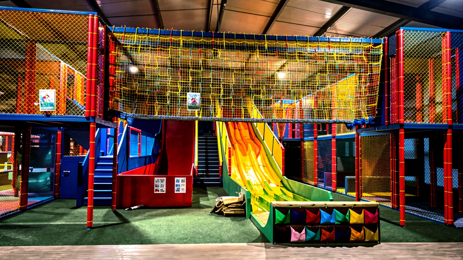 The colourful indoor soft-play frame with a yellow tube slide in the play barn at Fermanagh Fun Farm