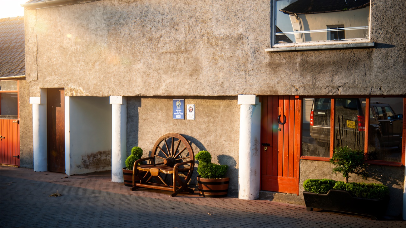 The tidy yard with its bright red stable doors and old wagon wheel