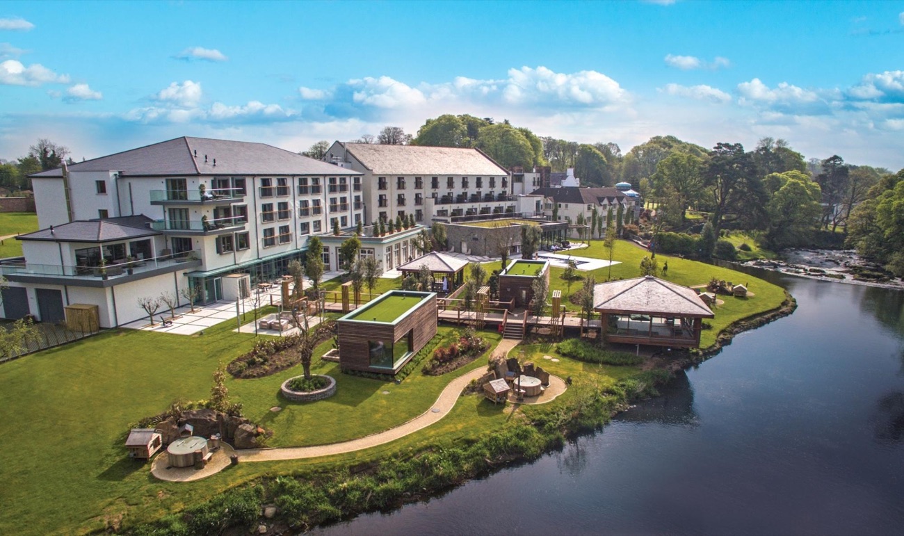 Galgorm Resort seen from the air, its riverside gardens and thermal bathing pavilions running down to the River Maine