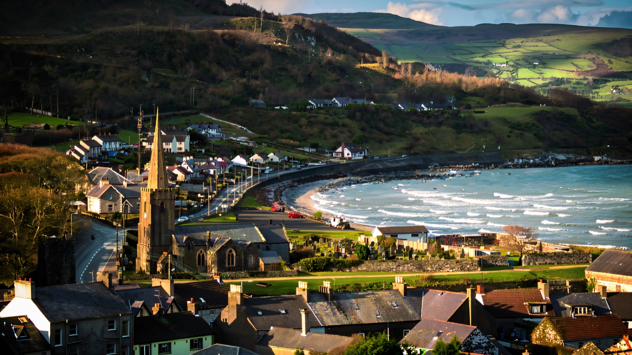 Glenarm village and its bay on the Antrim Coast, with the glens rising behind