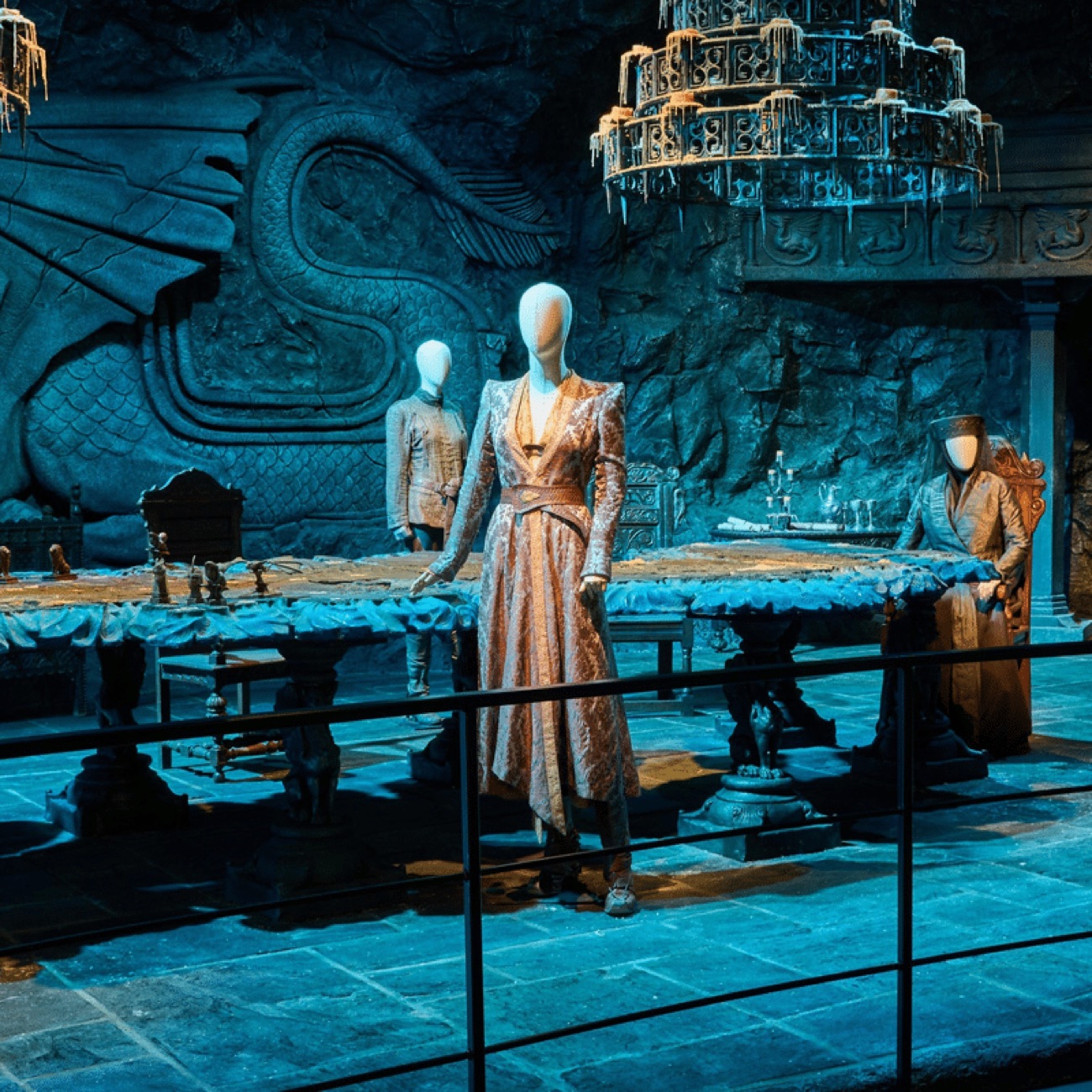 The blue-lit Dragonstone set with a carved stone dragon and a gowned costume on display