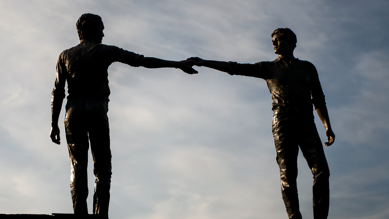 The two figures in silhouette against a dusk sky.