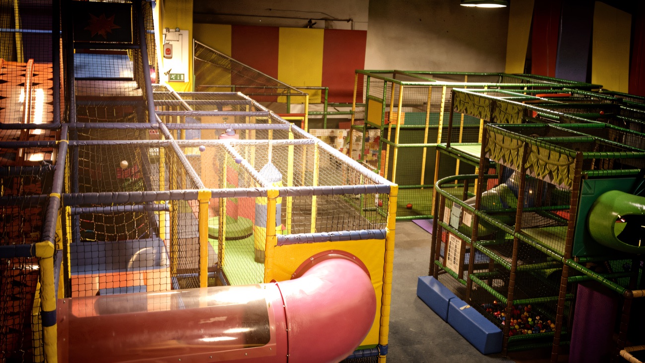 A wide view over the main frame, showing the pink tube slide, netted walkways and the ball pool beyond