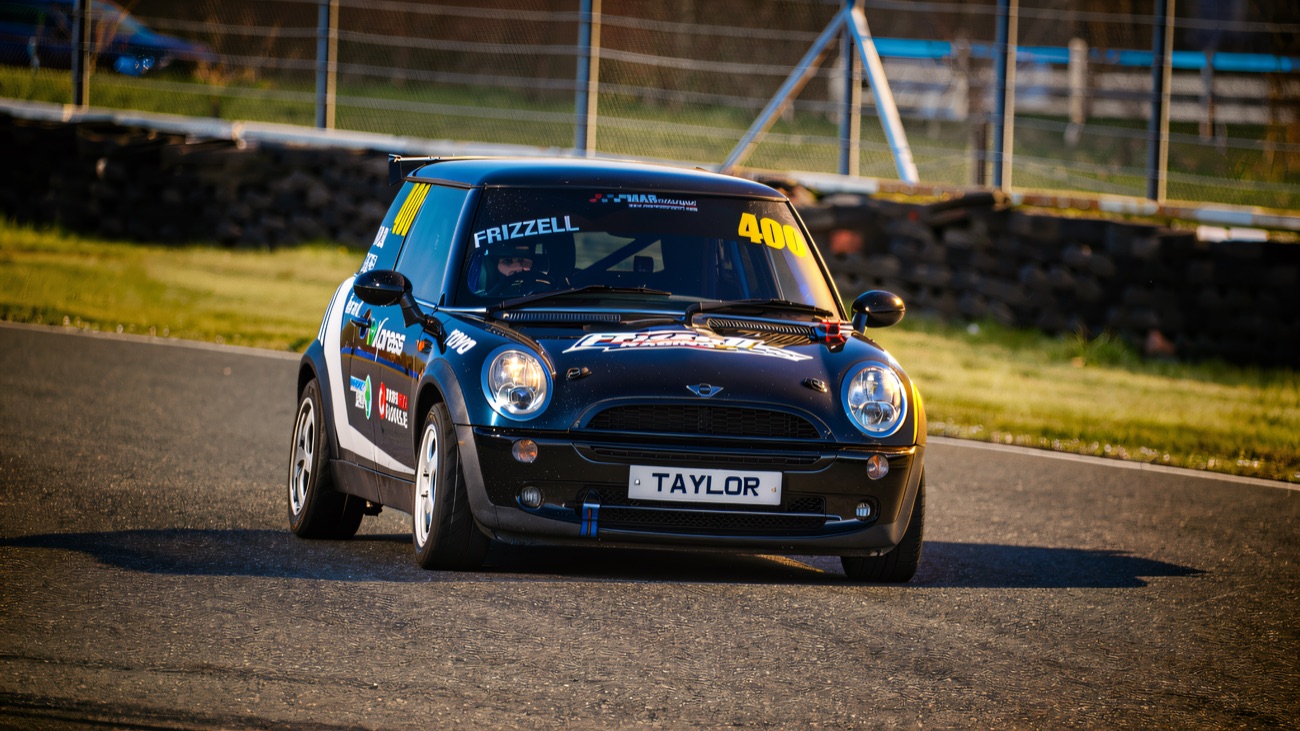 A saloon race car cornering hard at Kirkistown Racing Circuit