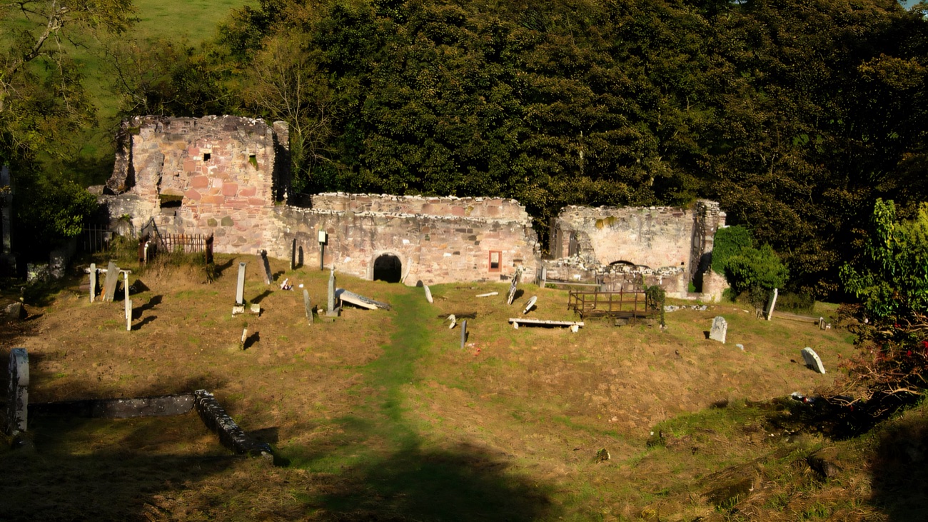 A straight-on view of the church front and its old headstones.