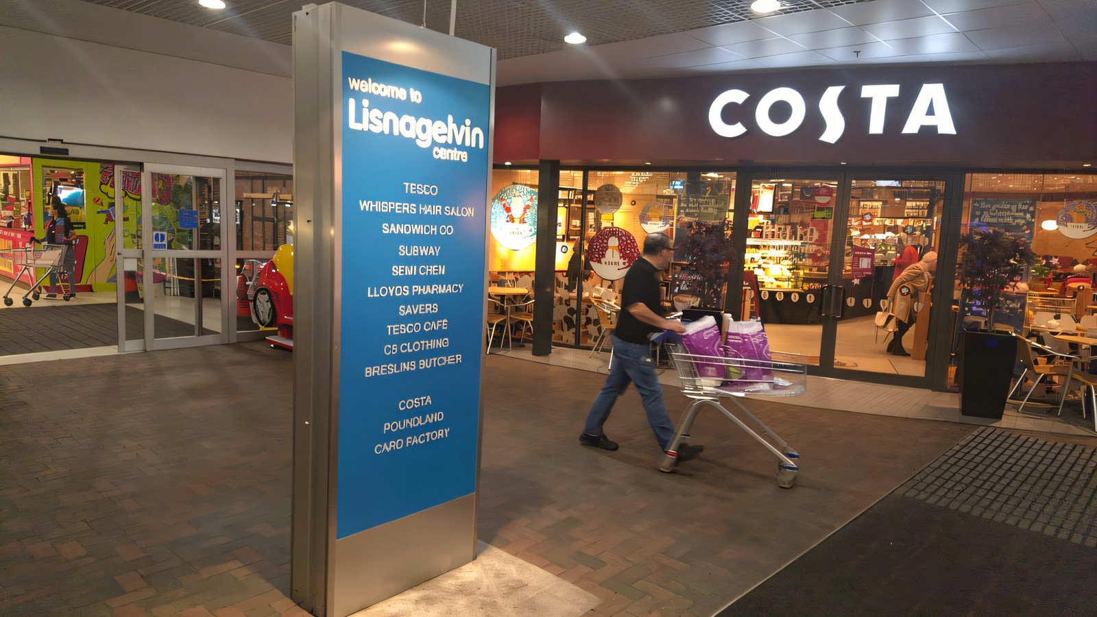 The entrance to Lisnagelvin Centre in Derry, with the welcome directory board and the Costa Coffee by the doors