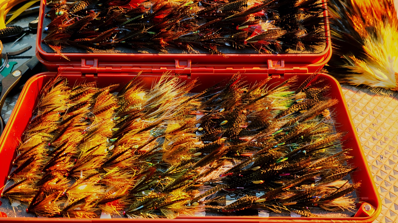 A box of hand-tied salmon and trout flies on the tying bench