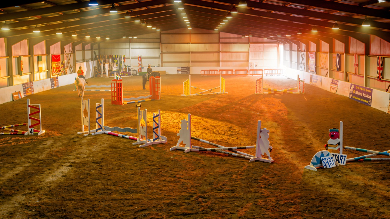 The indoor arena set out with coloured show jumps