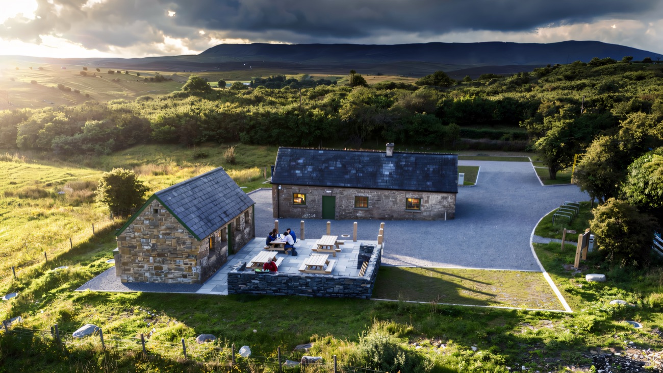 The restored stone cottages at the visitor hub, the flat ridge of Cuilcagh behind