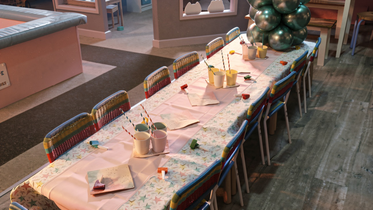 A long party table laid with pastel cups, blowers and balloons