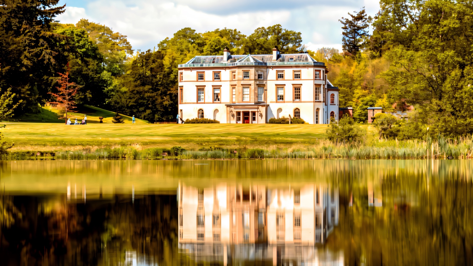Montalto's white mansion reflected in the lake, framed by lawns and woodland