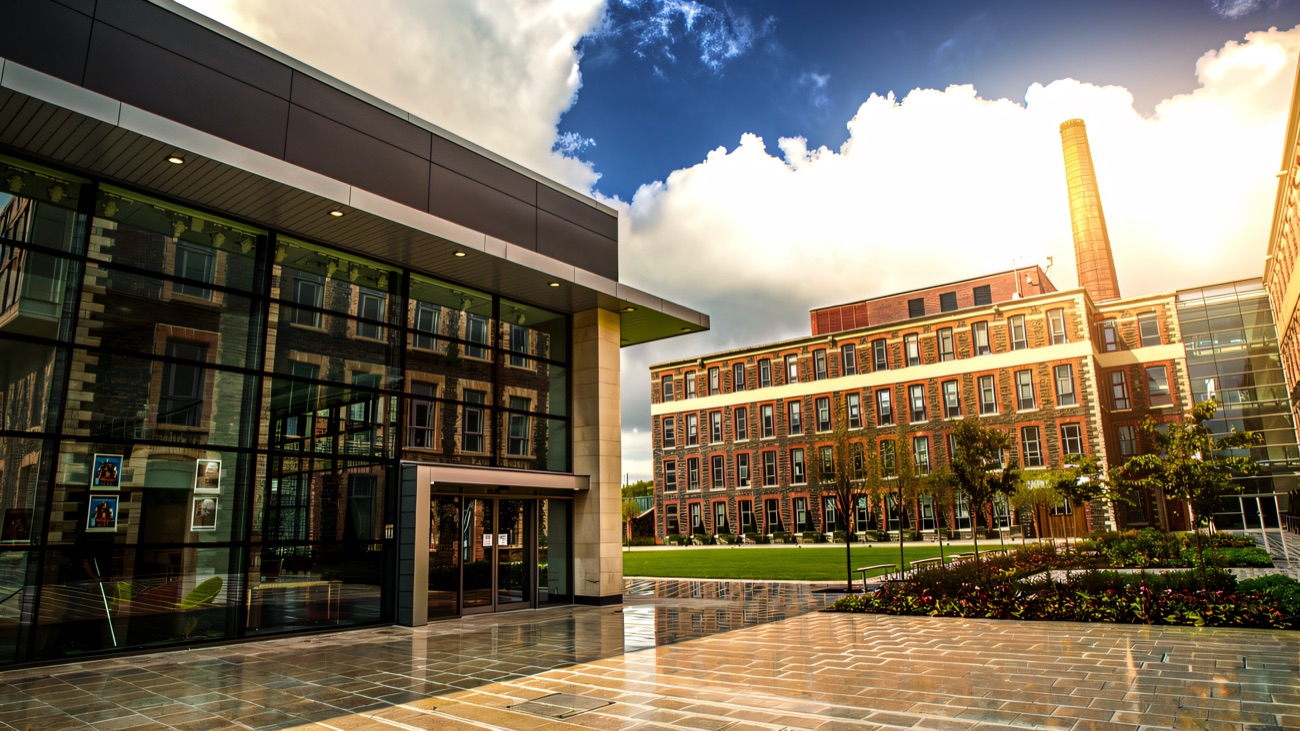 The landscaped courtyard and modern glass atrium at the heart of the Mossley Mill campus