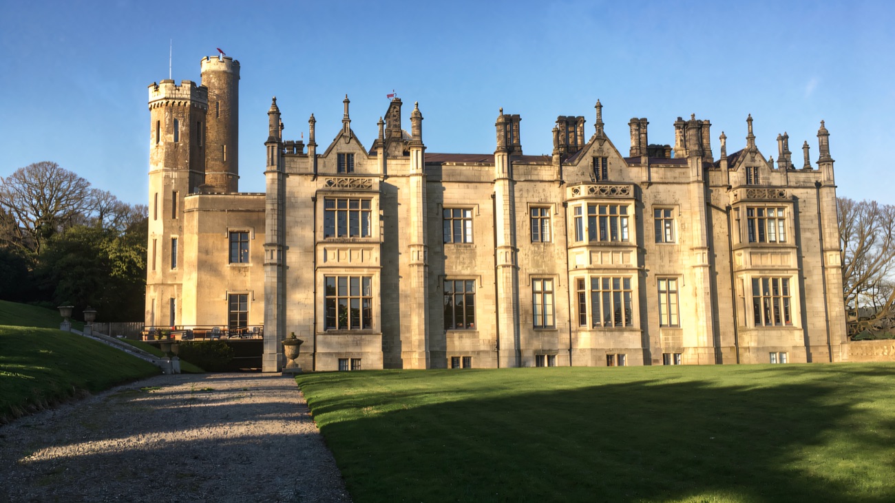 The grand facade of Narrow Water Castle in evening sun