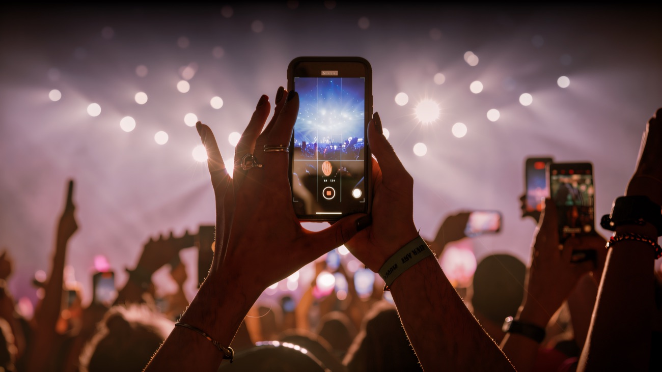 Silhouetted crowd watching a show under stage lights