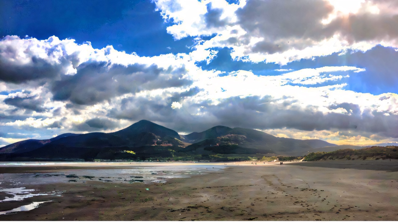 The wide strand with the Mourne Mountains rising behind