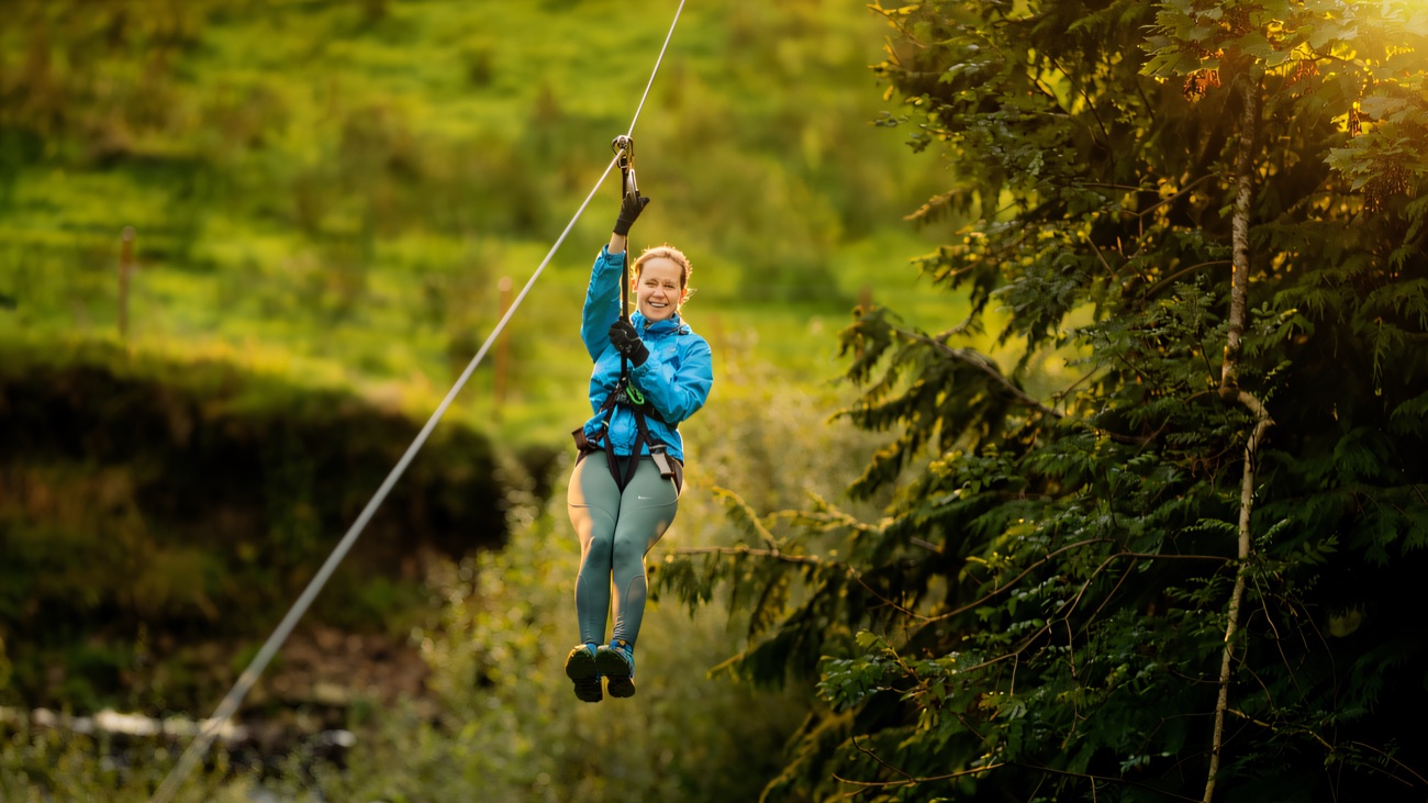 Zipping across the wooded glen, feet dangling over the green