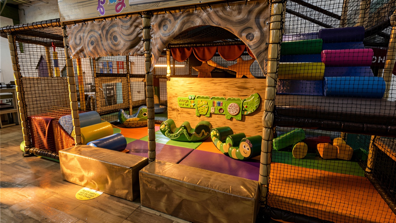 The toddler area under the Play Shed sign, with soft rockers and a low ball pool