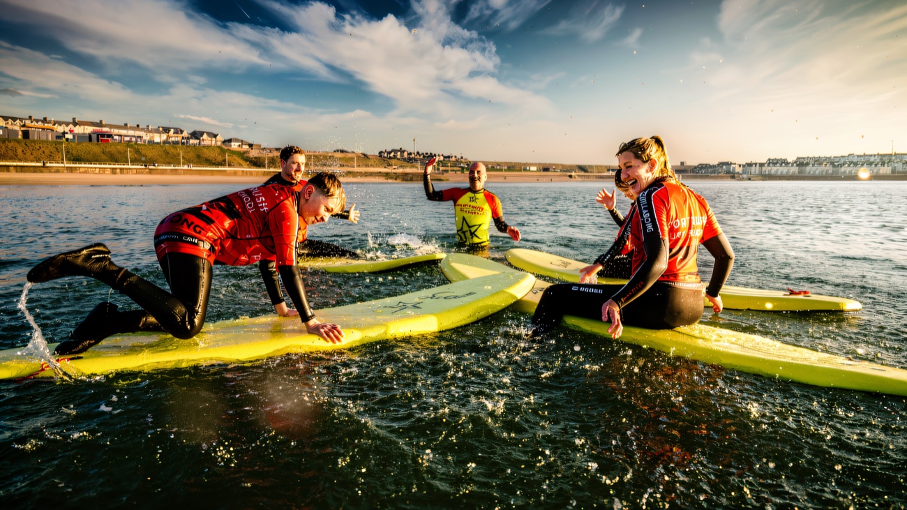Paddling out into the whitewater with the Portrush skyline behind